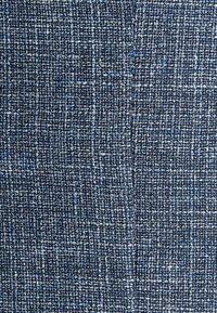 Tissu bleu tissé avec des nuances variées, présentant une finition texturée et un motif serré et structuré. Durable et adapté à diverses applications.