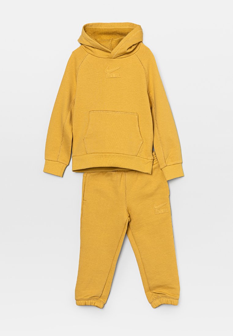 Sweatshirt à capuche jaune avec une poche avant et un logo brodé, associé à un pantalon de survêtement assorti avec un logo et des chevilles resserrées.