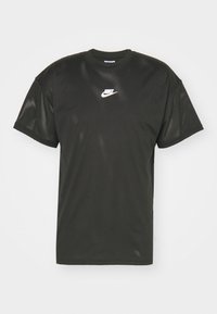 Camiseta de malla negra de Nike de manga corta con el logo blanco de Nike centrado en el pecho, presentada sobre un fondo claro y liso.