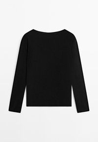 Top nero a maniche lunghe con scollo rotondo, caratterizzato da un tessuto morbido ed elastico e una silhouette aderente. Nessun motivo o accessorio visibile.