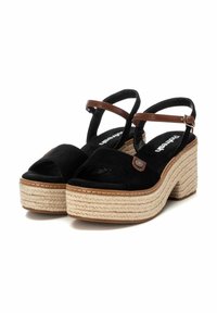 Sandalias de plataforma de ante negro con suela de espadrille trenzada, hebillas de cuero marrón en el tobillo y diseño de punta abierta.