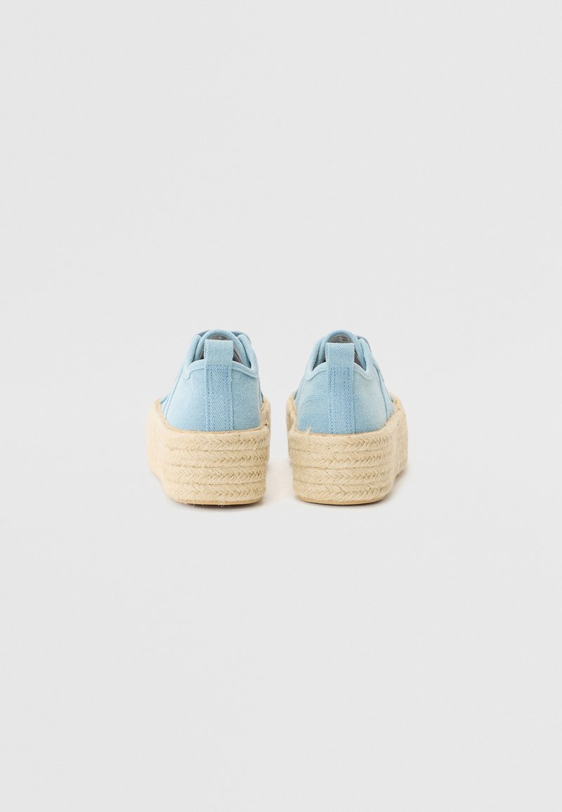 Scarpe in tela azzurro chiaro con un design arrotondato, caratterizzate da una sola piattaforma in juta intrecciata spessa e linguette del tallone rinforzate per una maggiore stabilità.