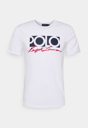 Biała bawełniana koszulka z krótkim rękawem, z wyraźnym granatowym logo "POLO" oraz czerwonym napisem "Ralph Lauren" poniżej. Okrągły dekolt.