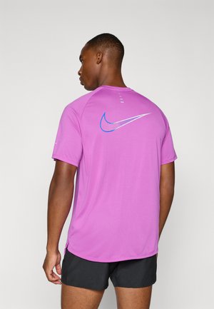 T-shirt à manches courtes Nike en rose vibrant, avec un logo bleu et argent au dos, texture lisse et design respirant.