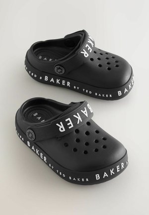 Saboti negri din material plastic, cu perforații pentru ventilație, având o curea neagră și o marcă albă "BAKER by TED BAKER" în jurul tălpii.