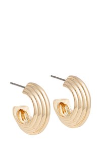 Boucles d'oreilles créoles en ton or avec un design nervuré, une forme courbée et une finition polie. Dotées d'un fermoir à tige pour un port sécurisé.