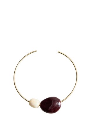 Collier ras du cou en métal couleur or ouvert avec une grande pierre rouge foncé et une pierre blanche plus petite.