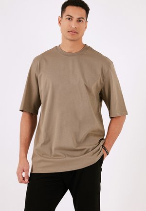 Khaki short-sleeve t-shirt made of lightweight fabric. Features a round neckline and relaxed fit. Minimal design with no patterns or accents.