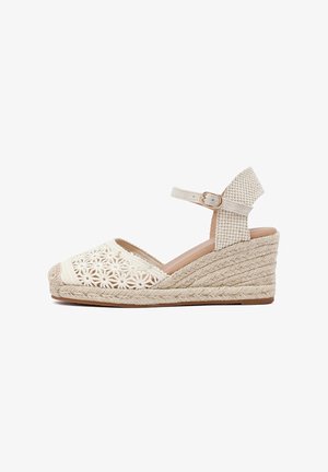 Wedge sandal with a woven jute heel, cream floral lace design, and adjustable ankle strap in a textured material.