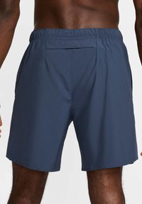 Herrbadbyxor i mörkblått, tillverkade av ett lätt material. Har en elastisk midja och två sidofickor, med en enkel design.