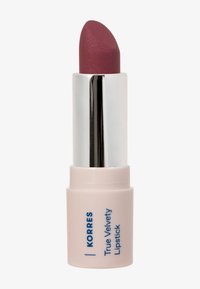 Matte mauve huulipuna hopeisessa putkessa ja vaaleanpunaisessa pohjassa, jossa lukee "Korres True Velvety Lipstick", valkoista taustaa vasten.