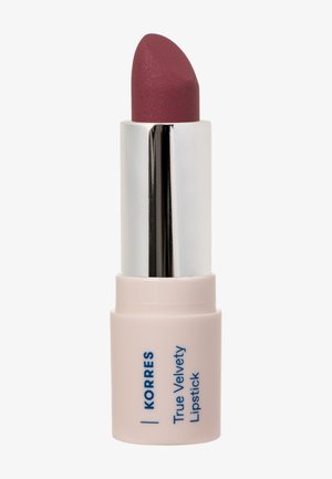 Mattes Mauve Lippenstift mit silberner Hülse und hellrosa Basis, beschriftet mit "Korres True Velvety Lipstick" auf weißem Hintergrund.
