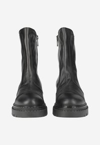 Bottines en cuir noir avec une finition lisse, zips latéraux et semelles en caoutchouc épaisses et texturées. Présente un bout rond et un design épuré.