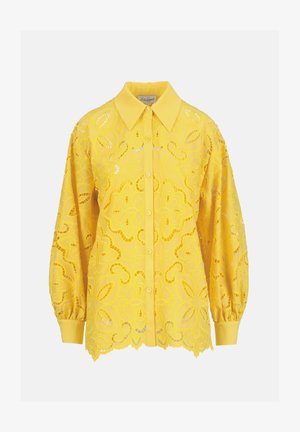 Camicia gialla a maniche lunghe con bottoni, motivo floreale traforato in pizzo, colletto appuntito e polsini aderenti.