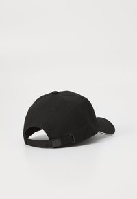 Svart baseballcaps laget av stoff, med en buet skygge, justerbar stropp bak, og et teksturert bakpanel.