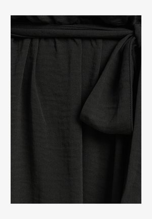 Zwart geweven stof met een zachte textuur, voorzien van een geraffineerde taille en een strikdetail voor sluiting. Inclusief een soepele, gedrapeerde uitstraling.