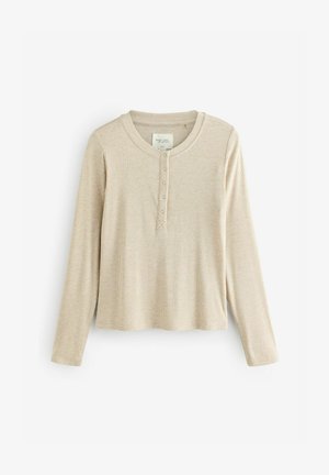 Beżowa koszula z długim rękawem typu henley, charakteryzująca się prążkowaną fakturą, okrągłym dekoltem, czterema guzikami i prostym dołem.