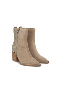 Botas de tobillo de ante beige con punta afilada, cremallera lateral y tachuelas plateadas decorativas en el tacón. Tacón de bloque de madera grueso.