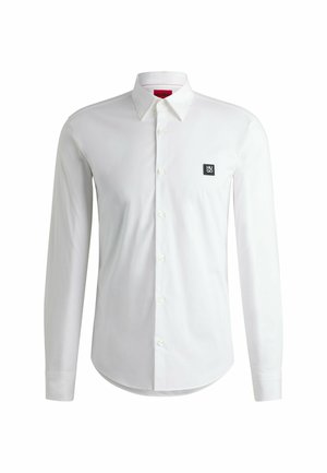 White long-sleeve shirt made of smooth fabric, featuring a button-down collar and a small black logo patch on the left chest.