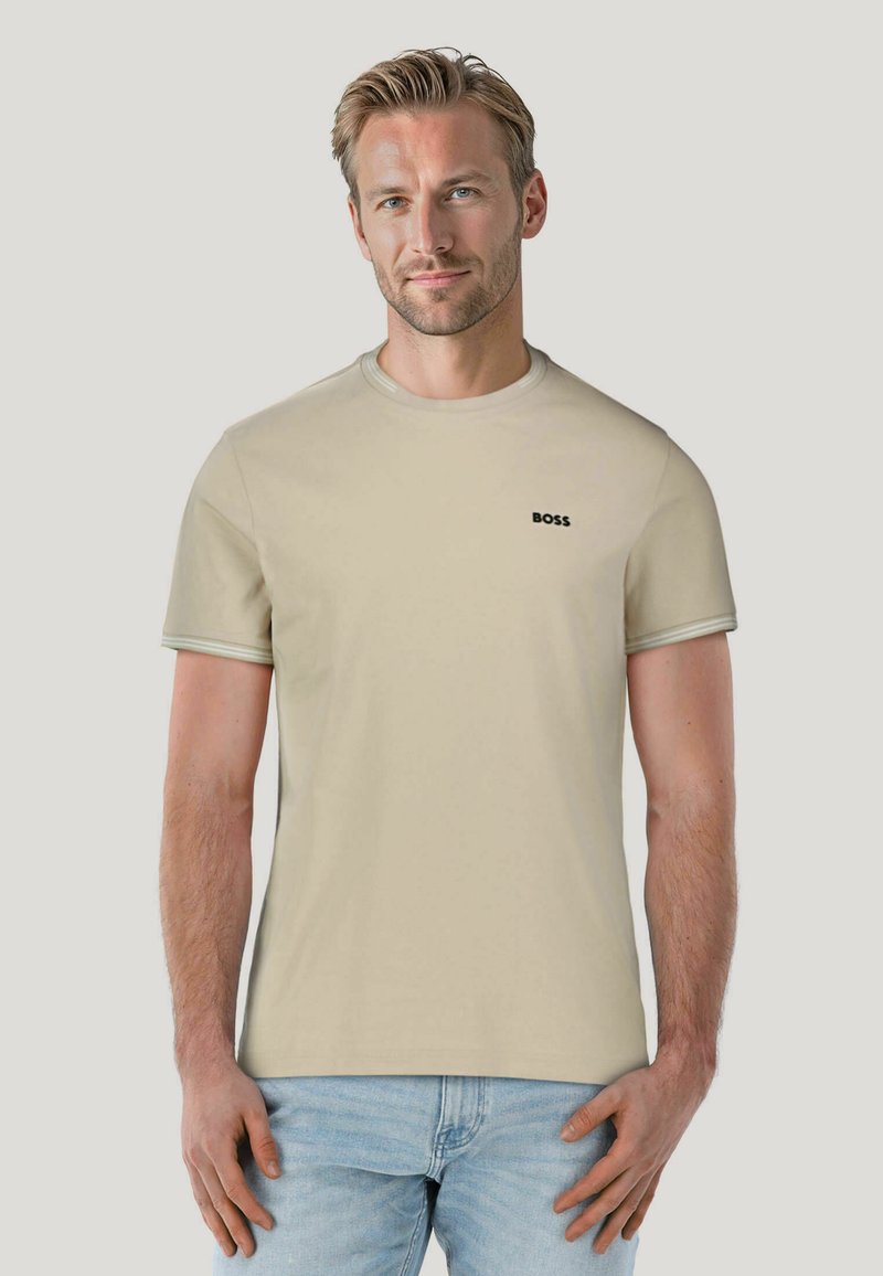 Light beige short-sleeve t-shirt made of cotton. Features a crew neck design and a small black "BOSS" logo on the left chest.
