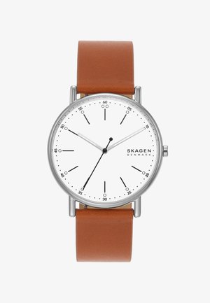 Runde silberne Uhr mit weißem Zifferblatt, schwarzen Stunden- und Minutenzeigern, braunem Lederarmband und dem Logo „SKAGEN DENMARK“ auf der rechten Seite.