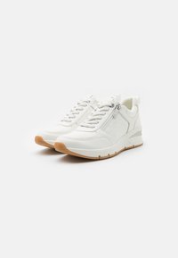 Le scarpe da ginnastica bianche presentano una parte superiore texturizzata, dettagli in argento e una suola in gomma. Hanno una chiusura con lacci frontale e una cerniera laterale per indossarle facilmente.