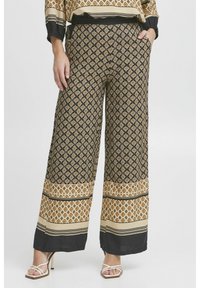 Pantalons larges avec un motif géométrique noir et or, agrémentés d'accents crème, présentant une taille haute, des poches latérales et une texture lisse.