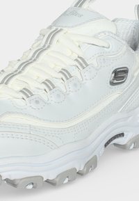 Λευκό sneaker Skechers με παχιά σόλα, λεπτομερή ραφή, λευκά κορδόνια με γκρι ρίγες και λογότυπο Skechers στο πλάι και στη σόλα.