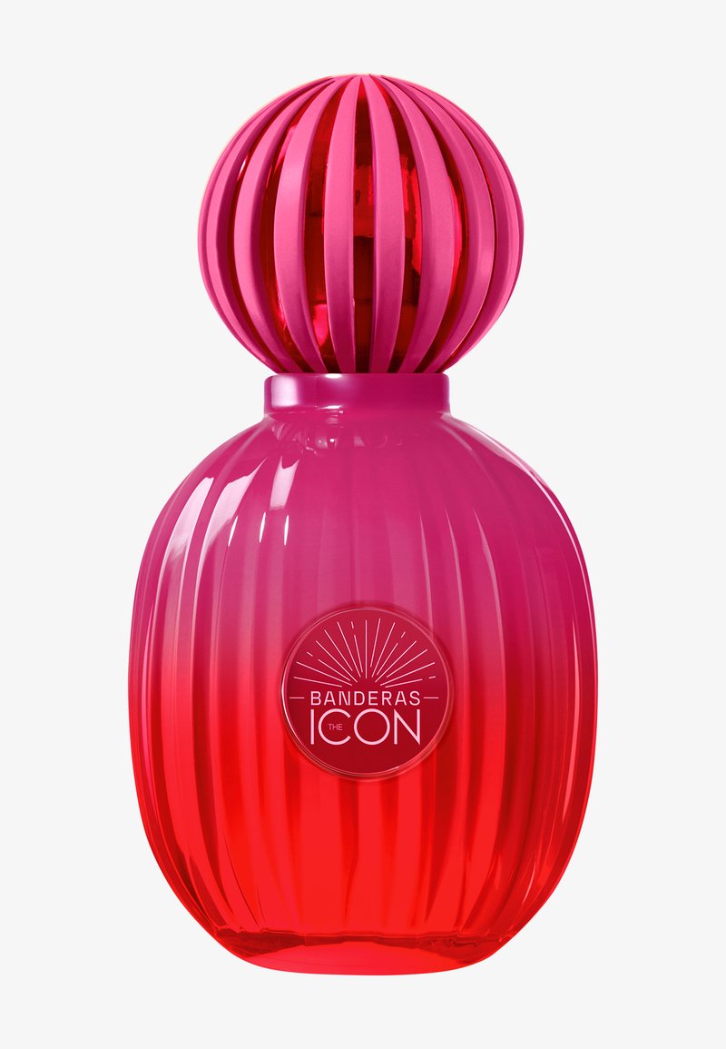 Rød og pink ribbet parfume flaske med rund stribet hætte og "Banderas The Icon" label på fronten.