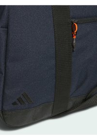 Blue fabric backpack with black accents, featuring a zipper with an orange pull tab and three black stripes logo on the side.