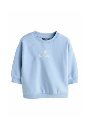 Hele sinine pusakleit pehmest materjalist. See on ümara kaeluse ja lühikeste varrukatega. Kaunistatud valge tekstiga "I ❤️ SNACKS".