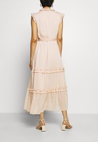 Vestido maxivestido rosa claro con mangas cortas con volantes, cintura ajustada y acentos de volantes en la parte inferior, con una tela fluida y texturizada.