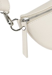 Biała torebka skórzana o teksturowanej powierzchni, w kształcie zakrzywionym. Posiada srebrny zamek błyskawiczny, metalowe elementy oraz odpinany pasek do wszechstronnego użytku.