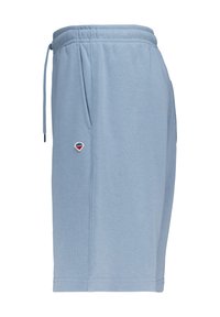 Shorts en coton bleu clair avec taille à cordon, poches latérales et un petit logo brodé sur le côté gauche. Texture douce et coupe décontractée.