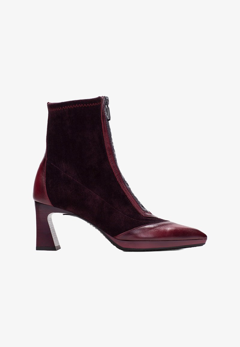 Botas de tobillo burdeos con punta afilada, parte superior de ante y cierre de cremallera. El tacón tiene forma de bloque con un acento plateado texturizado.