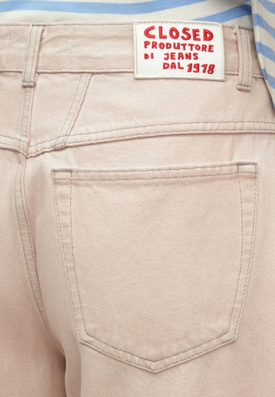 Ροζ ξεθωριασμένο τζιν με ετικέτα που γράφει "CLOSED PRODOTTORE DI JEANS DAL 1978." Διαθέτει πίσω τσέπες και ορατή ραφή.