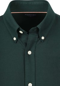 Dunkelgrünes Hemd mit Knopfleiste und einem strukturierten Kragen, das weiße Knöpfe und kontrastierende Nähte an der Innenseite des Kragens aufweist.