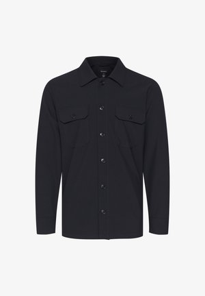 Melna ilga piedurkne krekls ar pogu priekšā, divām krūšu kabatām ar vāciņiem un norādītu apkakli. Gluda auduma tekstūra.