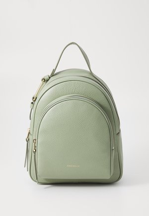 Green leather backpack with a rounded shape, featuring a top handle and gold-tone hardware. Two zippered compartments with textured finish.