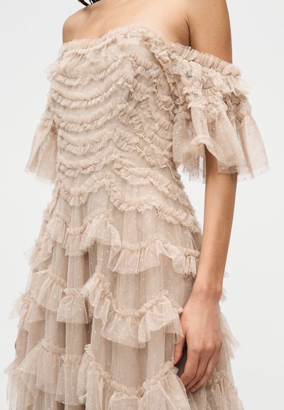 Beiges schulterfreies Kleid aus geschichtetem, strukturiertem Stoff mit Rüschen und Sternmuster sowie kurzen, ausgestellten Ärmeln.