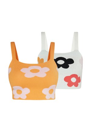 Twee mouwloze gebreide crop tops, de ene oranje met lichtroze bloemen, de andere wit met zwarte, oranje en roze bloemen.