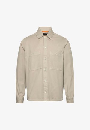 Beige långärmad skjorta med knappar, två bröstfickor, krage och knäppta ärmslut.