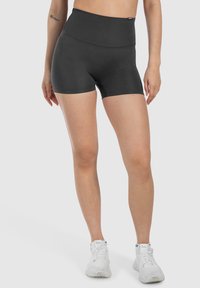 Pantalones cortos atléticos negros de cintura alta con una tela suave y elástica, que presentan un diseño ajustado y sin patrones o detalles visibles.