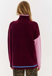 Bordowy i różowy sweter z dzianiny z wysokim kołnierzem, z niebieskim akcentem na dole i luźnym, swobodnym krojem.