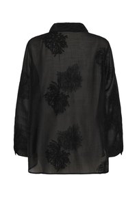Black sheer blouse featuring floral embroidery, collared neckline, long sleeves, and a loose fit. Textured fabric adds depth to the design.