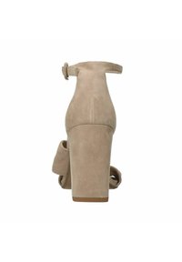Beige suède hoge hak sandaal, met een brede blokhak, enkelband met gesp en een zachte stoffen strikdetail aan de zijkant.
