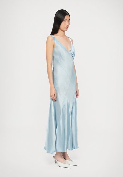 Φόρεμα από γαλάζιο σατέν με ντρα�παρισμένο V-λαιμόκοψη και σιλουέτα Α, διακοσμημένο με λεπτές τιράντες και φούστα που ανοίγει προς τα κάτω. Συνδυασμένο με λευκές γόβες.