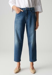 Jeans in denim blu con una vestibilità comoda, dotati di due tasche anteriori, chiusura con bottone e dettagli di cucitura visibili.