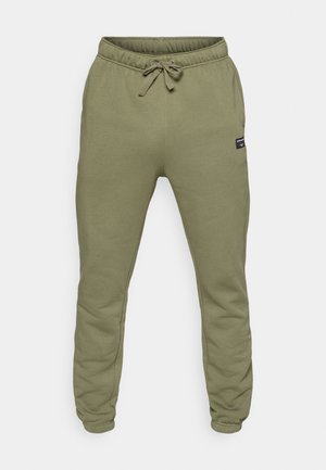 Olive green sweatpants made of soft fabric, featuring an elastic waistband with drawstring, and tapered legs. Small brand tag on the side.