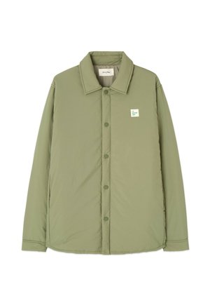 Chaqueta acolchada verde claro con cuello tipo solapa, cierre de botones a presión y una etiqueta de marca cuadrada en el pecho. Textura suave, diseño casual.